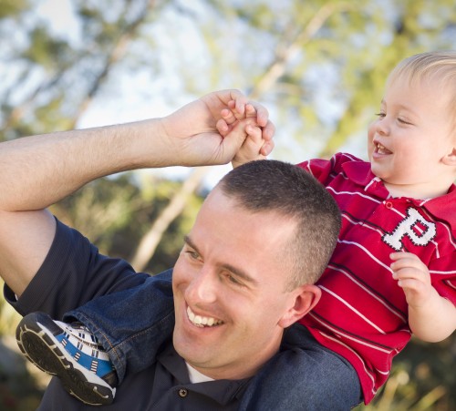 Young Laughing Father and Child  Having Piggy Back Fun.