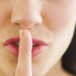 Young woman with finger on lips, close-up