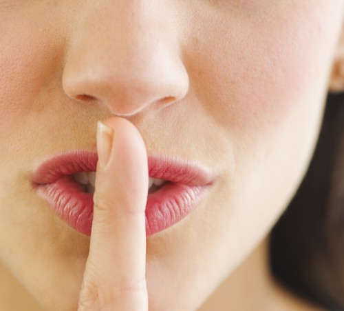 Young woman with finger on lips, close-up