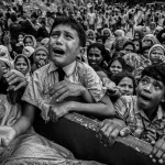 Hjá Cox's Bazar, Bangladesh. Rohingya flóttafólk berst um mataraðstoð frá hernum.